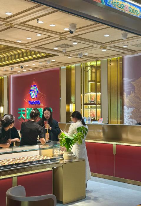 10月28日,在北京市天雅珠宝城某品牌柜台,顾客正在挑选黄金饰品。新华网记者 闫雨昕 摄